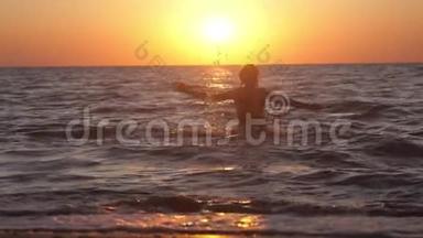 女人在令人惊叹的日落时分在海里玩水。 节假日期间自由度假旅游.. 慢动作。 1920x1080